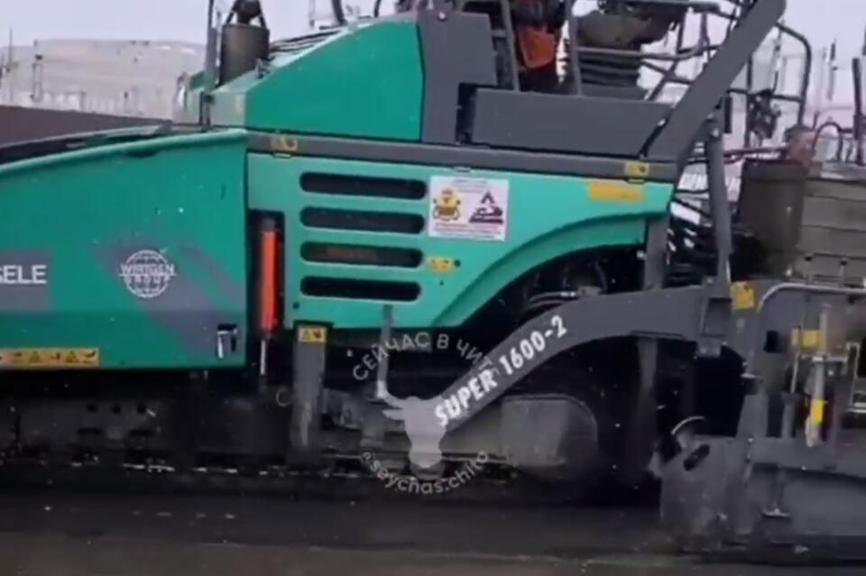 Дорожники на улице Трактовой в Чите укладывают асфальт в снег и лужи